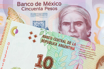A macro image of a pink, plastic fifty peso bank note from Mexico paired up with a colorful ten...
