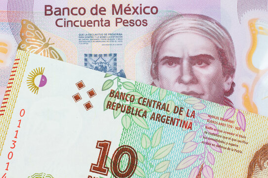 A macro image of a pink, plastic fifty peso bank note from Mexico paired up with a colorful ten peso note from Argentina.  Shot close up in macro.