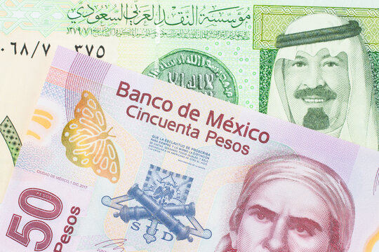 A macro image of a pink, plastic fifty peso bank note from Mexico paired up with a green and yellow on riyal bank note from Saudi Arabia.  Shot close up in macro.