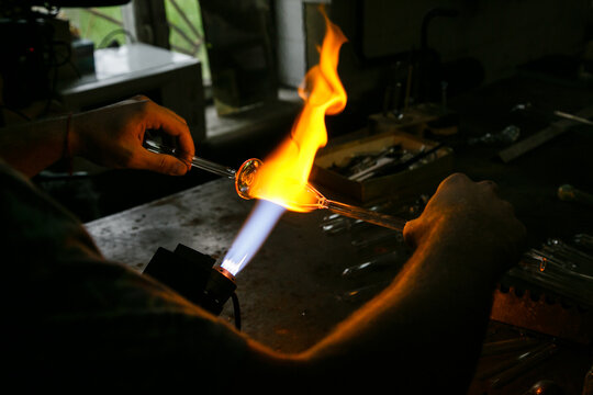 Process of handmade glassworks manufacturing with glass blowing burner - Powered by Adobe