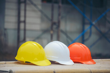 Safety helmet (hard hat) for engineer, safety officer, or architect, place on cement floor. Yellow,...