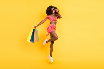 Full size photo of smiling attractive good mood girl enjoy summer go shopping wear costume set isolated on yellow color background