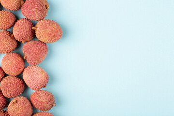 Lychee on a blue background, flat lay, empty space for text