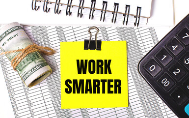 On the desktop there are reports, notepads, a calculator, a cash and a yellow sticker with the text WORK SMARTER. Business concept