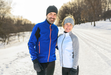 mature running couple in the winter standing together in nature