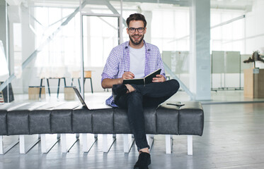 Millennial businessman write in notebook in office