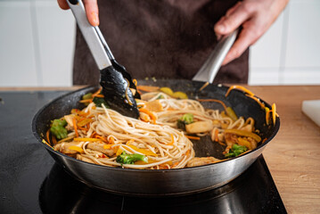 Chef cooking delicious udon wok.