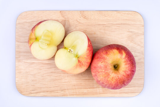 Cut an apple in half and place it on a cutting board isolated on a white background, Sweet and juicy fruit, top view
