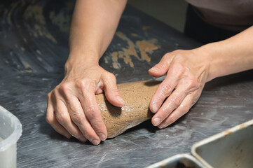 Close-up baker making bread, female hands, kneading dough, cooking