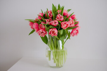 a bunch of pink tulips on the white table