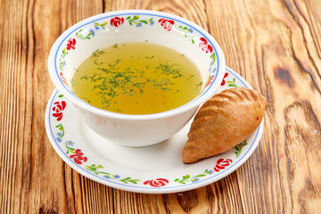 Hot meat broth with fresh cereal bun