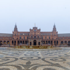 The famous Spanish square in Seville during a sunrise covered in fog. It is built in 1928 for the Ibero-American Exposition. It is a landmark with regionalism architecture and mixing elements.  - obrazy, fototapety, plakaty