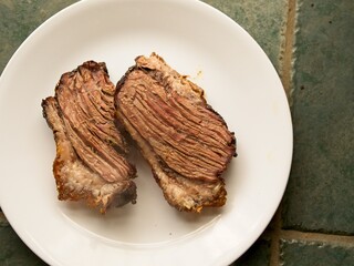 Slices of freshly grilled beef brisket on a white plate