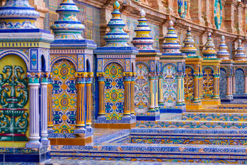 The typical ceramic and colourful benches of the famous Spanish square plaza de Espana) in Seville. It is built in 1928 for the Ibero-American Exposition. The benches all represent a region in Spain - obrazy, fototapety, plakaty