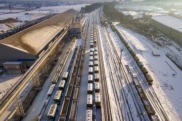 Fototapeta na wymiar Aerial view of cargo train loaded with crushed stone materials at mining factory. Railway transportation of grinded limestone ore