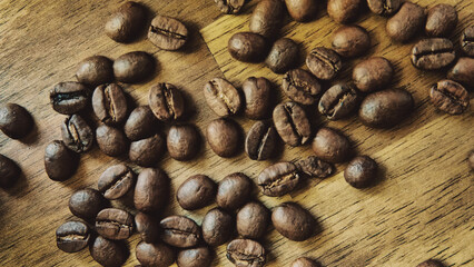 Close up of roasted coffee beans on wooden table. Top view.