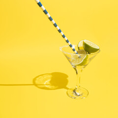 Martini glasses with vermouth, sugar and lime  on yellow background.