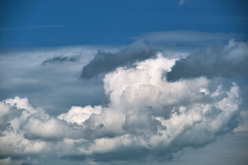 Bright landscape of white puffy cumulus clouds on blue clear sky