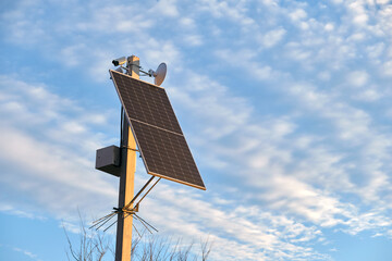 Obraz premium Solar photovoltaic panels mounted on city street pole for electricity supply of streetlights and surveillance cameras