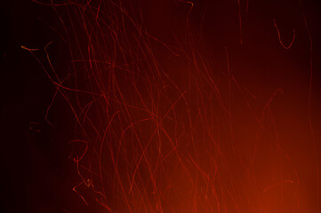 Red sparks of fire from a bonfire with a black background