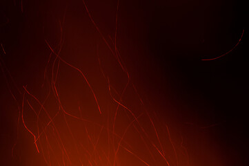 Red sparks of fire from a bonfire with a black background