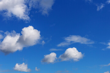 Fototapeta na wymiar blue sky with white cumulus clouds of various sizes as a natural background