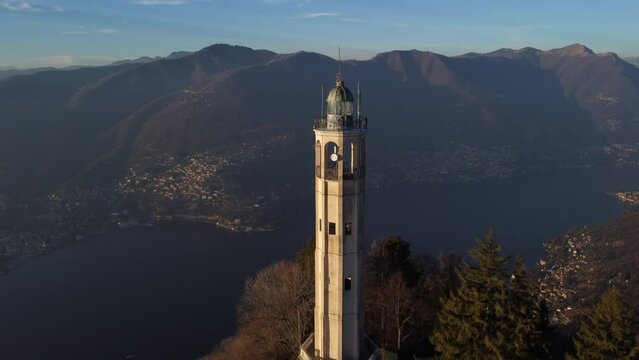 Aerial drone view of a lighthouse over Lake Como skyline with sunset light - Faro Voltiano (Volta Lighthouse) - Travel Destination, Brunate, Como, Lombardy, Italy