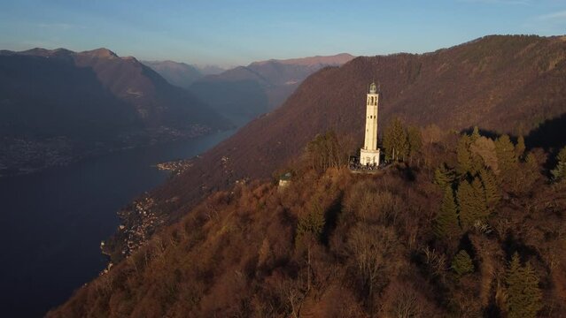 Aerial drone view of a lighthouse over Lake Como skyline with sunset light - Faro Voltiano (Volta Lighthouse) - Travel Destination, Brunate, Como, Lombardy, Italy
