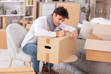handsome man writing with a marker pen on a box