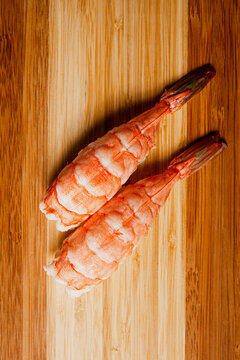 Sushi freshly prepared. Japanese food, sushi roll of shrimp in a wooden background. Fish and crustaceans slices. Front view with Copy Space.