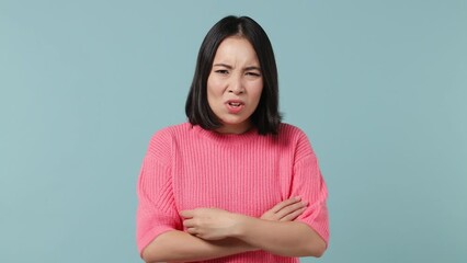 Displeased irritated sad angry young woman of Asian ethnicity 20s wears pink shirt closed eyes cover ears do not want to listen scream isolated on plain pastel light blue background studio portrait - Powered by Adobe
