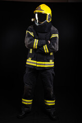 Obraz na płótnie Canvas Firefighter in full firefighting gear on a black background