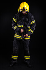 Firefighter in full firefighting gear on a black background