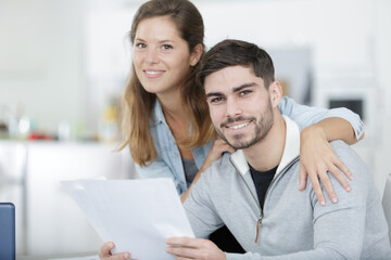 portrait of couple holding paperwork in the home