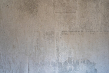 Old dirty wall paper backdrop. Weathered background texture of a damaged and wet material. Interior design of a vintage room. Wavy surface of the wall. Dirt stains and spots on the inner wall.