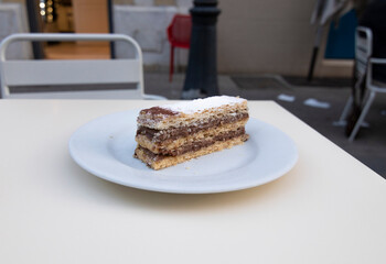 A puff pastry filled with chocolate on a table, outside a cafeteria. Confectionery concept.
