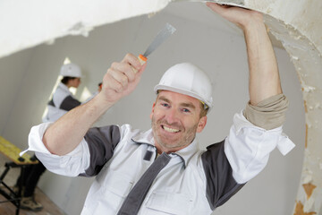 portrait of senior tradesman working on interior arch