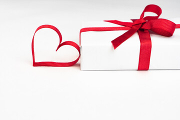 White boxes with red ribbons and decorative heart isolated on white background