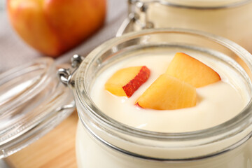Delicious yogurt with fresh peach in glass jar, closeup