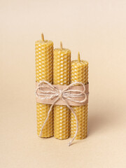 Set of handmade beeswax candles on beige background. Handmade eco product. Eco-friendly gift - obrazy, fototapety, plakaty