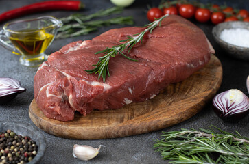 Fresh meat tenderloin with herbs, garlic, spices on a cutting board, macro. Fresh beef meat.