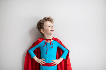 Little boy superhero with red cape. Happy smiling child. Success, motivation