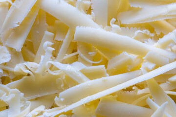 Macro shot of grated cheddar cheese on top of an uncooked lasagne, texture, background