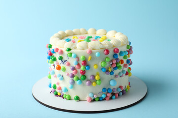 Cute bento cake with tasty cream on light blue background