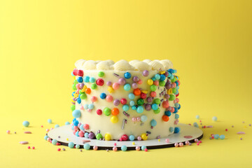 Cute bento cake with tasty cream on yellow background