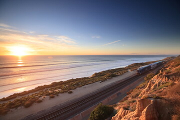 Amtrak trains along the San Diego coastline at dusk - obrazy, fototapety, plakaty