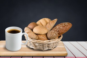 Tasty bread and a cup of coffee on the desk
