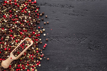 A set of peppers.Collage of different type pepper, Black ,white, pink and allspice peppercornsr, dried chili pepper.Top view. On a black background. free space for your text.