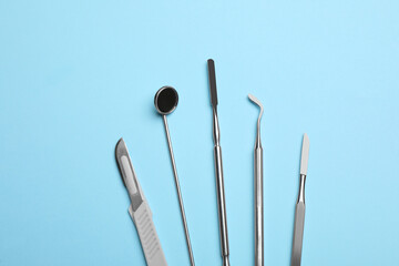 Set of different dentist's tools on light blue background, flat lay