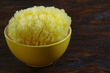 The Natural Sea Sponge. Premium Bath Sponge in a porcelain bowl on wooden backgrond